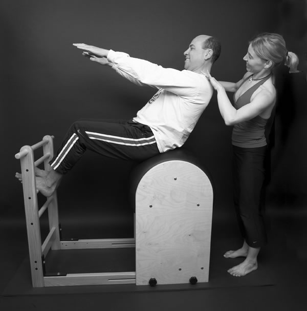 Robyn Baxter coaching a man on Pilates equipment.